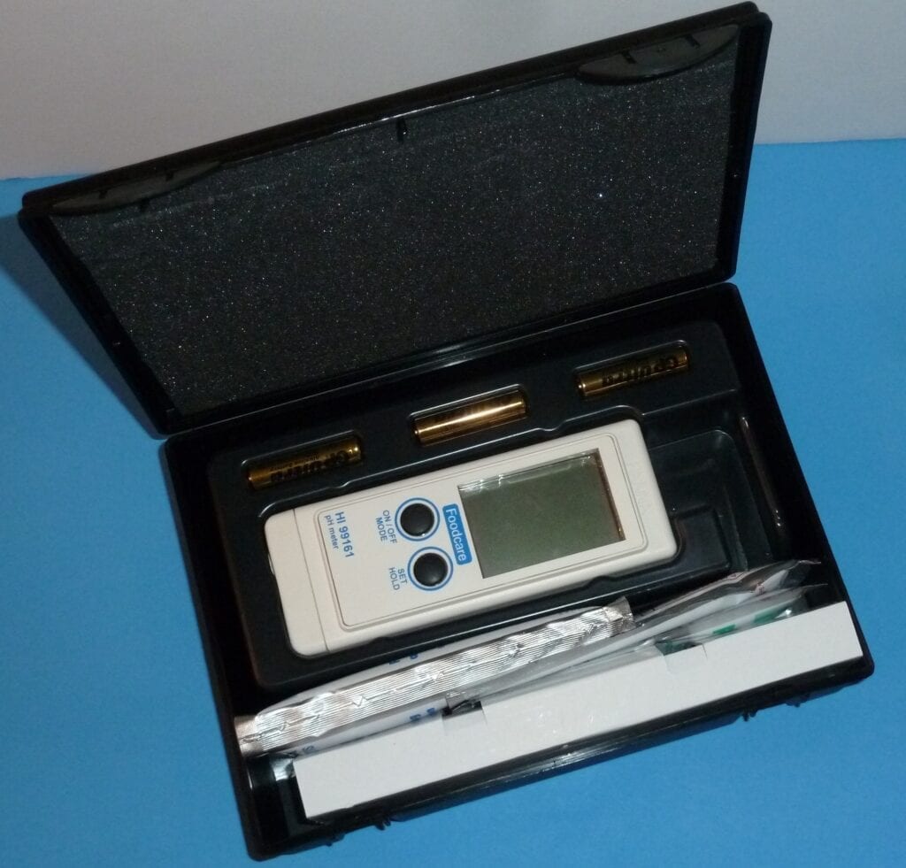 Portable electronic device in a black carrying case with accessories.