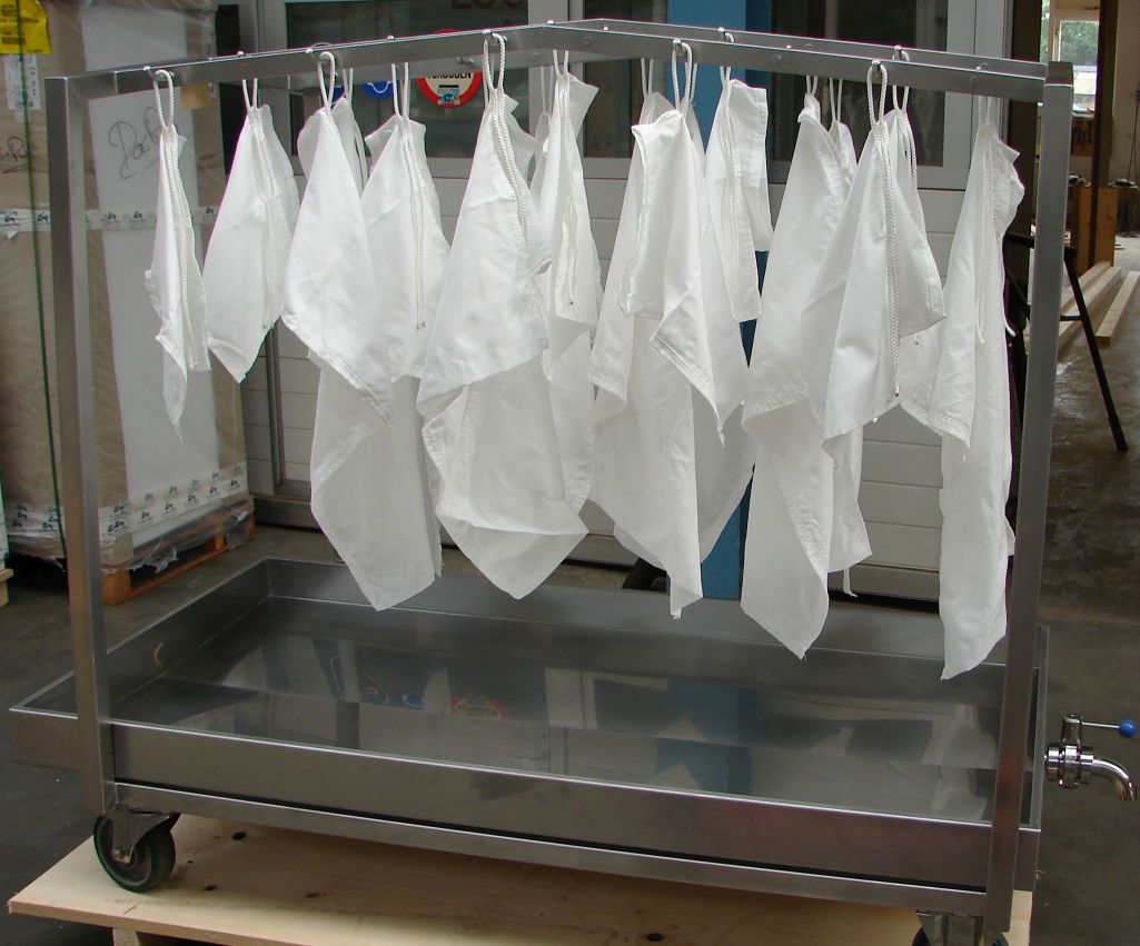 White cloths hanging on a metal rack for drying.