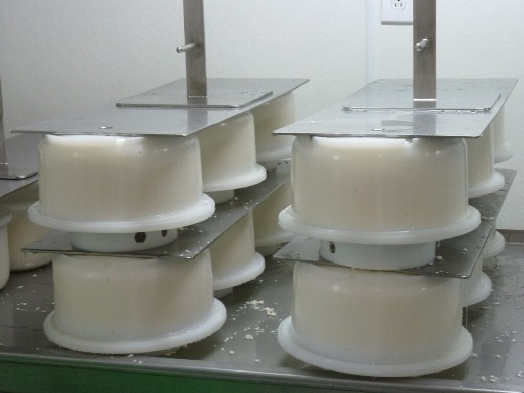 Close-up of white plastic gears or rollers on metal rods in machinery.