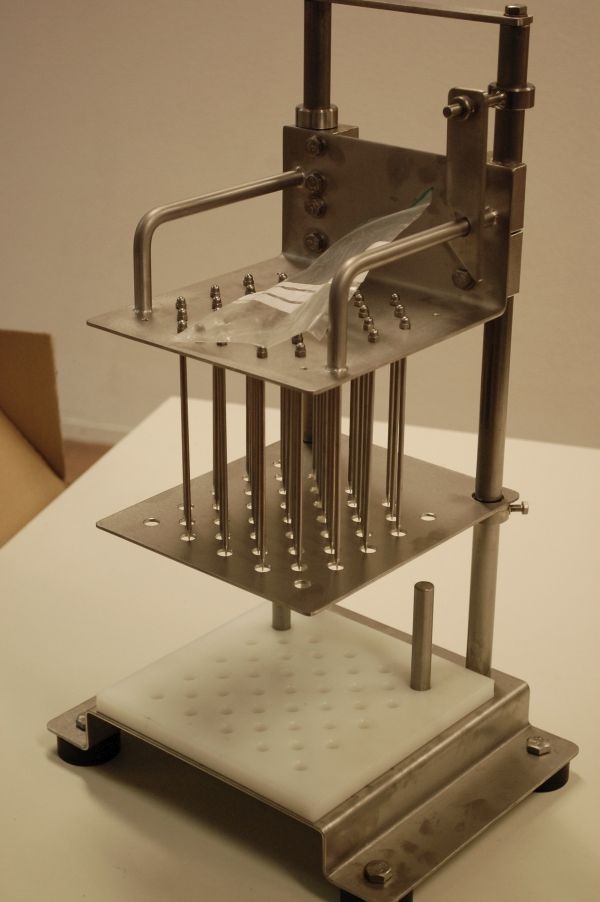 A metal mechanical device with rods and perforated plates.