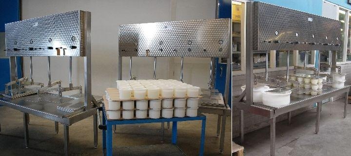 Machine packaging rows of white soap bars.