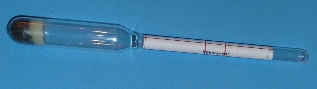 A close-up of a clear plastic pipette with measurement markings.