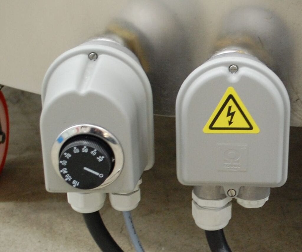 Close-up of electrical connectors with a voltage warning symbol.