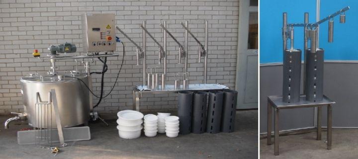 Industrial equipment with stacked white containers and black machinery against a brick wall.