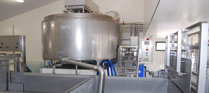 Industrial stainless steel tank in a production facility.