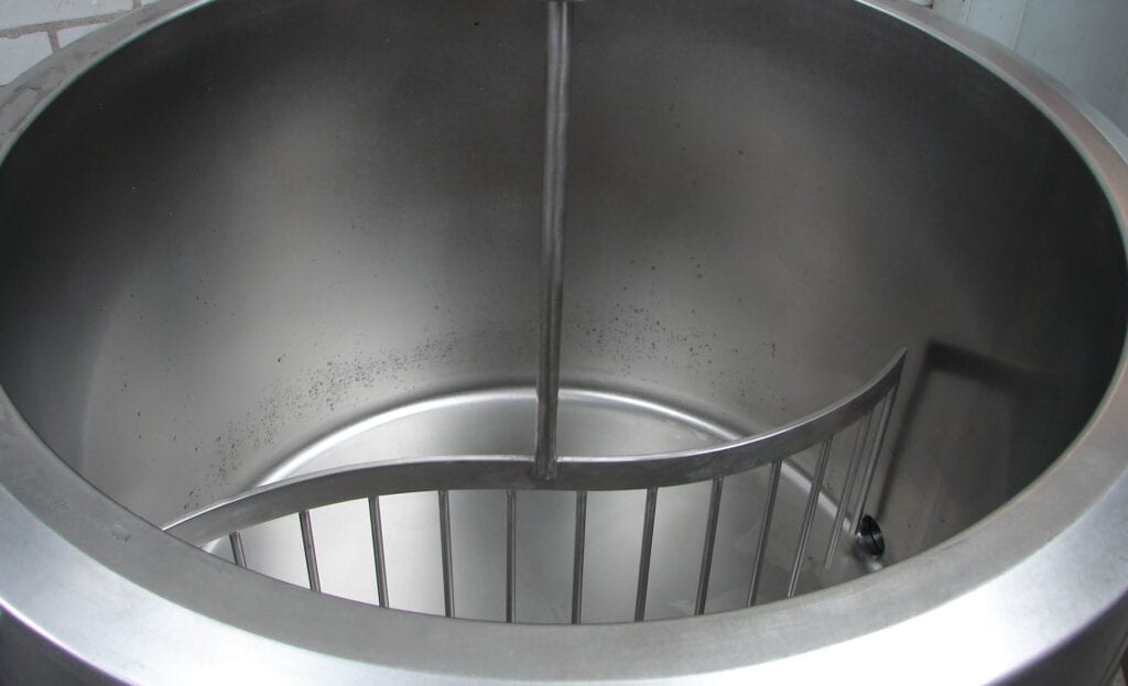 Top view of a spiral staircase inside a cylindrical metallic structure.